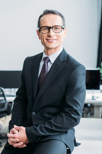 smiling-businessman-in-eyeglasses-sitting-on-table-V5AWVKC.jpg smiling-businessman-in-eyeglasses-sitting-on-table-V5AWVKC.jpg